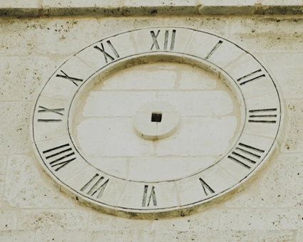 Immagine di un orologio sulla facciata di un palazzo. L'immagine rappresenta una delle caratteristiche principali dei contenuti che offre AXIA Academy: le competenze apprese sono evergreen.